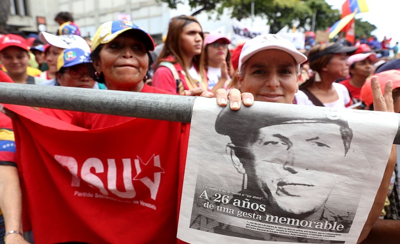 Pro-government protesters hold up a sign honoring Chavez.