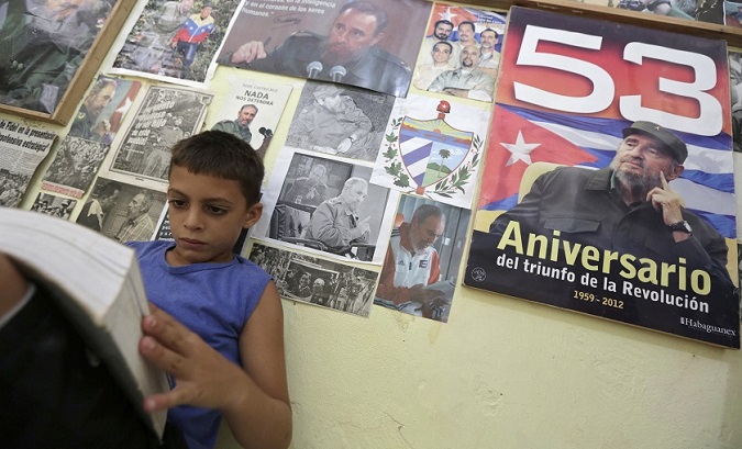 Marlon Mendez, an admirer of Fidel Castro, reads a book in his bedroom in San Antonio de los Banos, Cuba.