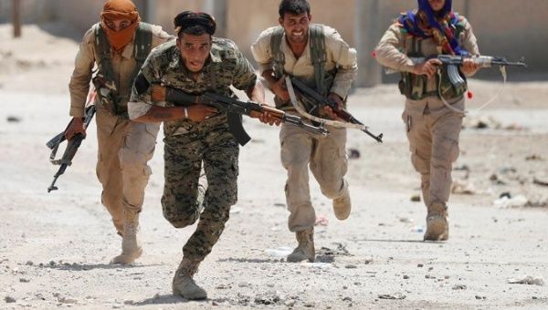 Kurdish fighters from the People's Protection Units, YPG, run across a street in Raqqa, Syria July 3, 2017.