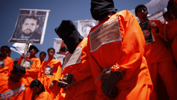 Former Guantanamo Bay detainees Walid al-Qadasi  and Sadiq Muhammad Saeed wear black hoods during a protest outside the U.S. embassy in Sanaa, Yemen.