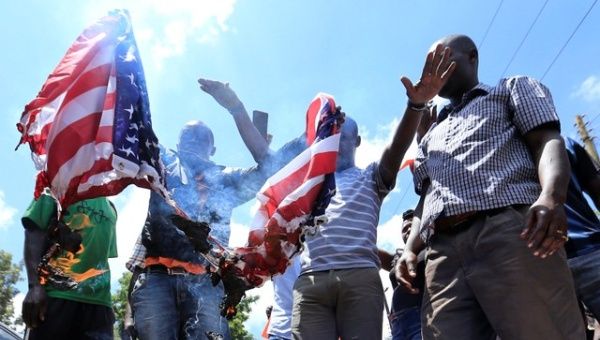 Supporters of Kenyan opposition leader Raila Odinga of the National Super Alliance (NASA) coalition burn a mock-up of the U.S. flag during a protest against U.S. Ambassador Robert Godec near the embassy building in Gigiri area of Nairobi, Kenya Feb. 16, 2018.