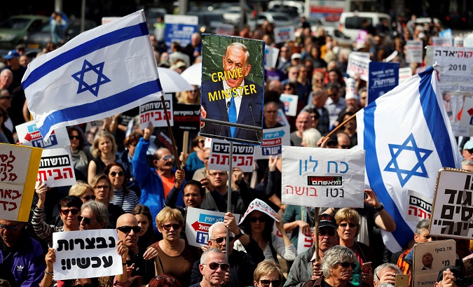 Protesters hold signs calling upon Israeli Prime Minister Benjamin Netanyahu to step down during a rally in Tel Aviv, Israel.