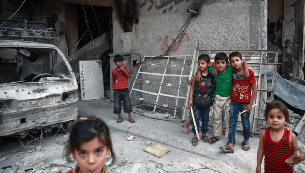 Children are seen near rubble of damaged buildings in the eastern Damascus suburb of Ghouta, Syria, July 17, 2017.