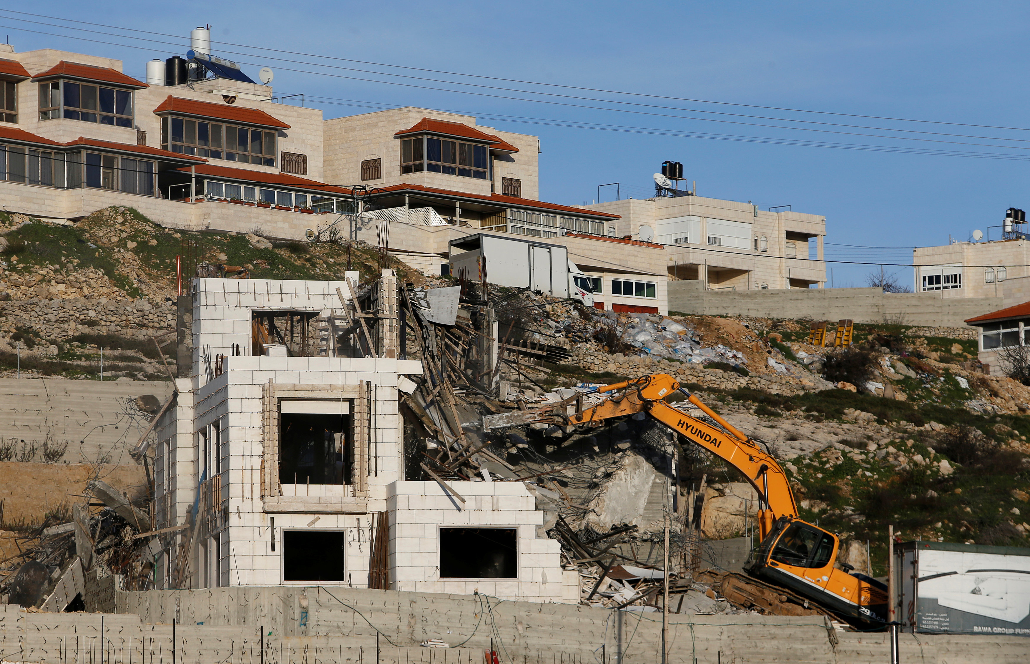 An Israeli machinery demolishes an under-construction Palestinian residential building near Hebron, in the occupied West Bank February 14, 2018.