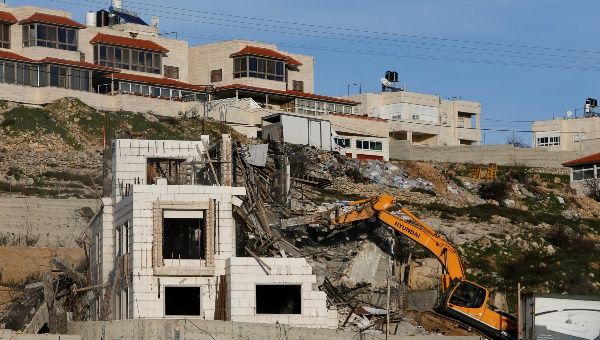 An Israeli machinery demolishes an under-construction Palestinian residential building near Hebron, in the occupied West Bank February 14, 2018. 