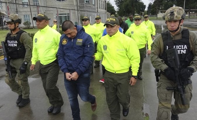 Prado (C) being escorted by security officials.