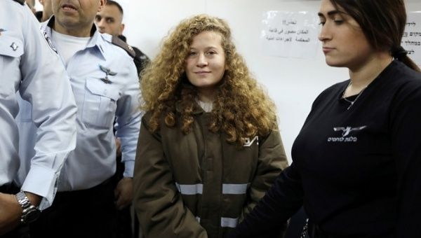 Palestinian teen Ahed Tamimi enters a military courtroom escorted by Israeli police at a prison near the West Bank city of Ramallah, Jan. 15, 2018. 