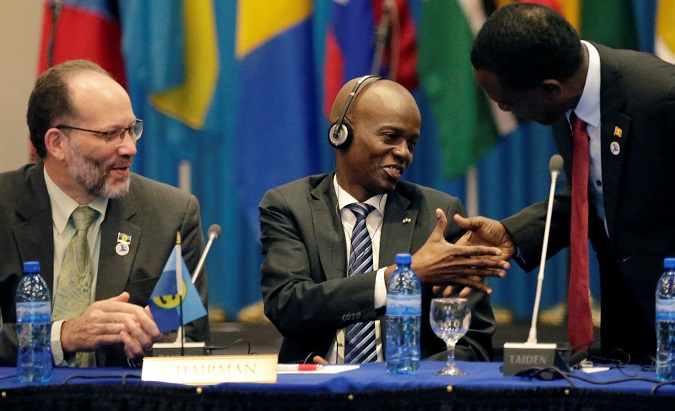 Haiti's President and Current Chair of the Caribbean Community, Jovenel Moise (C), shakes hands with former Chairman, Grenada's Prime Minister Dr. Keith Mitchell, while Secretary-General and Chief Executive Officer of the Caribbean Community, Ambassador Irwin LaRocque looks on, at the opening ceremony of the 29th Inter-Sessional Meeting of CARICOM Heads of Government in Port-au-Prince, Haiti February 26, 2018.
