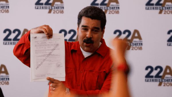 President Nicolas Maduro holds a document as he registers his candidacy for re-election at the National Electoral Council (CNE) headquarters in Caracas, Venezuela February 27, 2018.