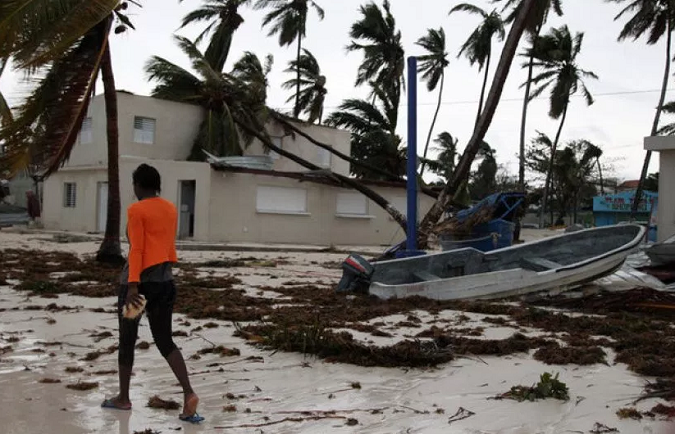 A woman walks among debris on the seashore in the aftermath of Hurricane Maria in Punta Cana, Dominican Republic, Sept. 21, 2017.