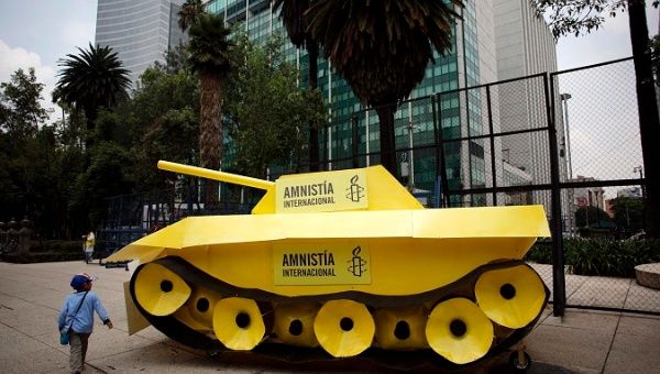 A child walks around a fake tank parked outside the US embassy during a protest held by Amnesty International in Mexico City..