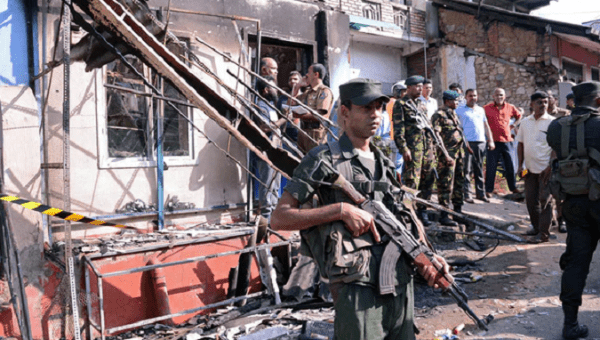 Sri Lankan troops stand guard near a burnt house after violence in Digana, a central district of Kandy. 