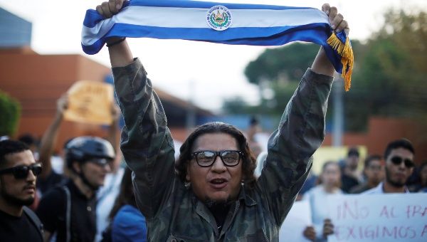 A man holds a Salvadoran flag during a protest against municipal and parliamentary elections results in San Salvador, El Salvador, March 6, 2018.
