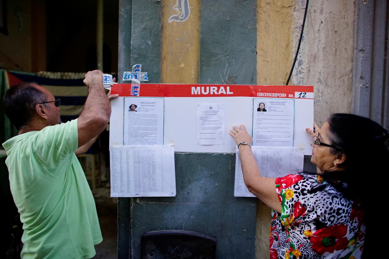 Election officials hang pictures and CVs of municipal assembly candidates moments before opening a polling station in Havana, Cuba Nov. 26, 2017.