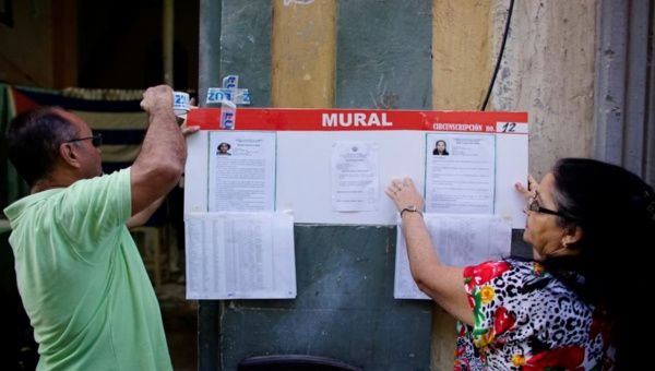 Election officials hang pictures and CVs of municipal assembly candidates moments before opening a polling station in Havana, Cuba Nov. 26, 2017.