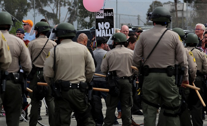A large police presence watches over protesters and supporters during the visit of U.S. President Donald Trump to view border wall prototypes in San Diego, California, U.S., March 13, 2018.