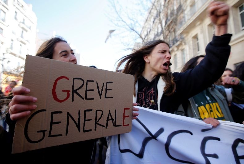 Protesters carry signs during during a national day of strike against reforms in France.