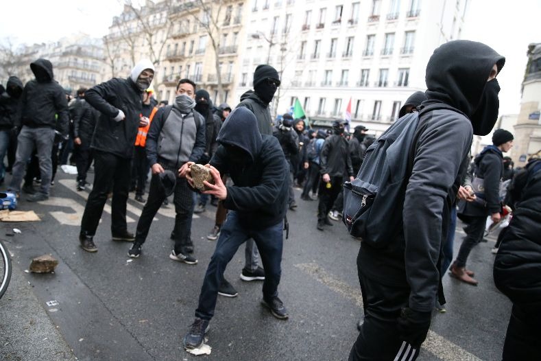 Masked protesters clash with riot police as they attend a demonstration during a national day of strike against reforms in Paris, France.