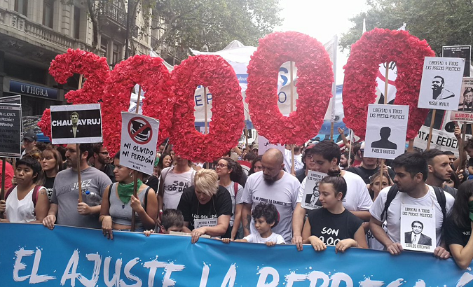 Demonstrators carry the number 30,000 to represent the victims detained or forcibly disappeared under the military dictatorship.