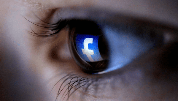 A picture illustration shows a Facebook logo reflected in a person's eye, March 13, 2015. 