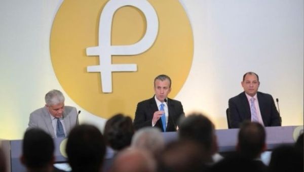 The Petro's logo is seen behind Venezuela's Vice President Tareck El Aissami (Center) as he speaks during a meeting with ministers in Caracas, Venezuela.