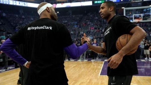 Professional basketball players Vince Carter (Left) and Al Horford (Right) shake hands before their NBA game at Golden 1 Center in Sacramento, California. Both players and teammates wore warm-up shirts in remembrance of unarmed Stephon Clark who was fatally shot by Sacramento Police 20 times last week.
