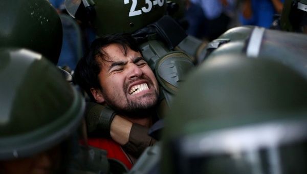A demonstrator is detained during a protest demanding an end to profiteering in the education system in Santiago, Chile, March 27, 2018. 