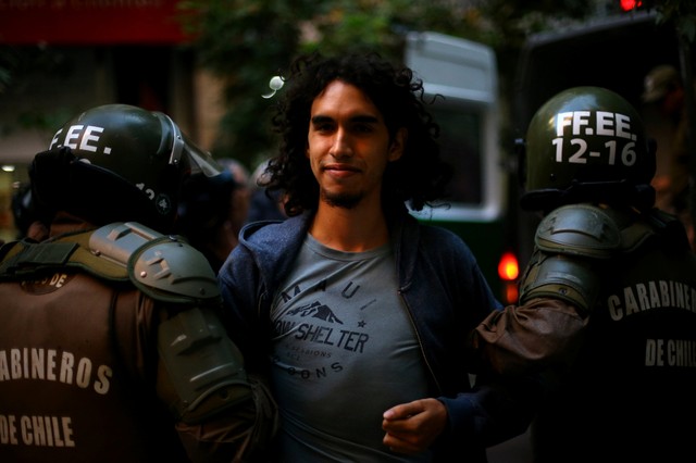 A student is detained outside the Constitutional Tribunal during a protest demanding an end to profiteering in the education system in Santiago, Chile March 27, 2018. 
