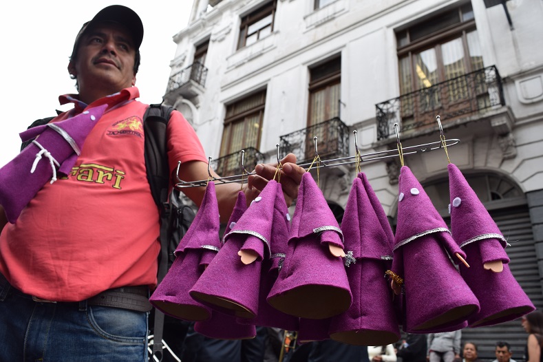 A vendor sells 'Cucurucho' souvenirs in the streets of Quito's historic center on Good Friday.