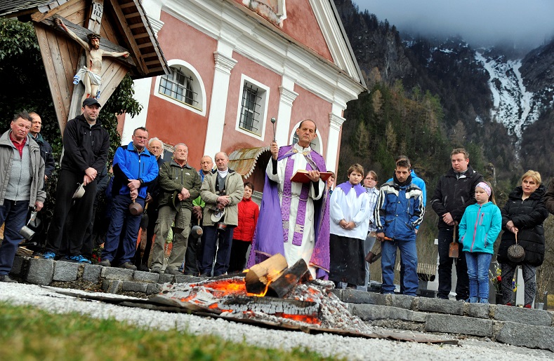 A priest blesses the holy fire during the Holy Saturday services ahead of the Easter Vigil ceremony in Log pod Storzicem, Slovenia, March 31.