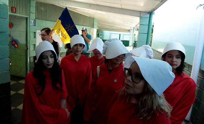 Activists dressed in the costumes from The Handmaid's Tale series prepare before voting during the presidential election, at a polling station in San Jose, Costa Rica, April 1, 2018.