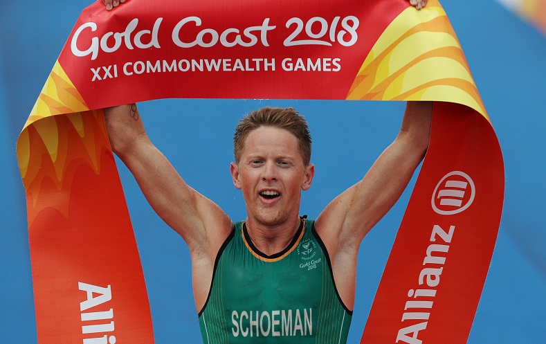 South African triathlete and past Olympic winner Henri Schoeman held the finish line banner in triumph after taking first place on Thursday at the 2018 Commonwealth Games Men's Final.