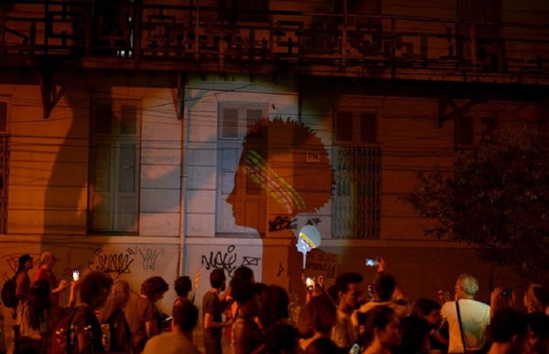 Demonstrators project an image on the wall representing the late Rio de Janeiro city councillor Marielle Franco during a protest against her shooting one month after her death. 