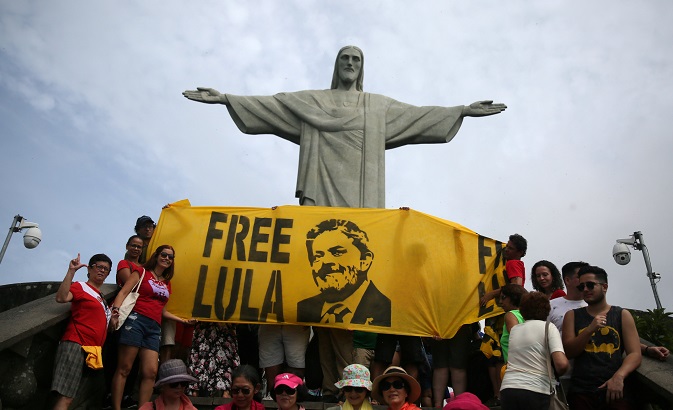 Supporters of former Brazilian President Luiz Inacio Lula da Silva display a banner in front of the statue of Christ the Redeemer in Rio de Janeiro, Brazil April 14, 2018