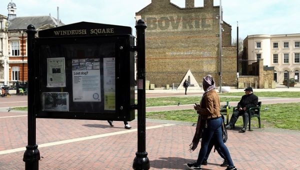 People walk past a sign on Windrush Square in the Brixton district of London, Britain April 16, 2018.