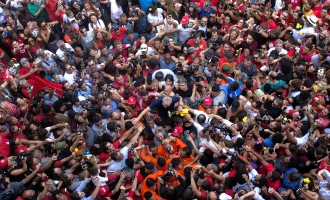 Former Brazilian President Luiz Inacio Lula da Silva is hoisted away by the crowd before surrendering to federal police.