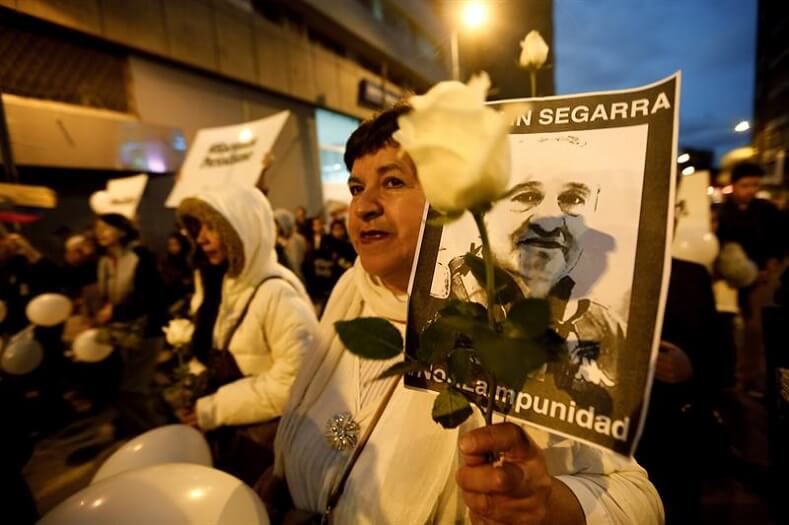 One protester carries the picture of Efrain Segarra, whose body has not yet been returned to his family.