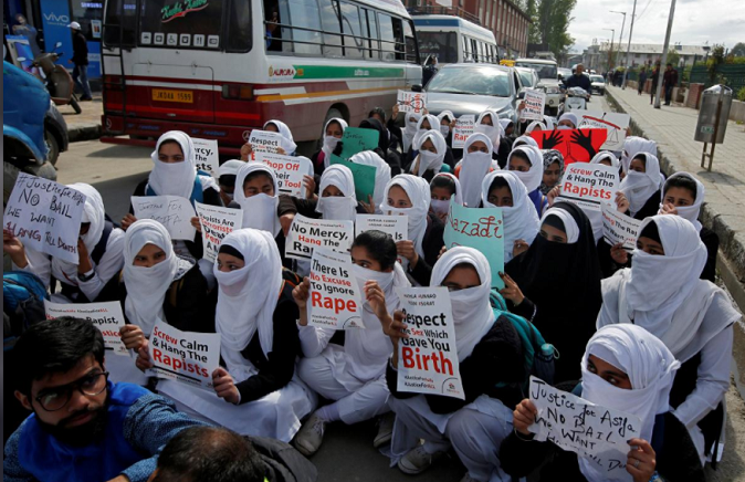 Schoolgirls holding placards sit in a road during a protest against the rape of several minor girls, in Srinagar April 17, 2018.