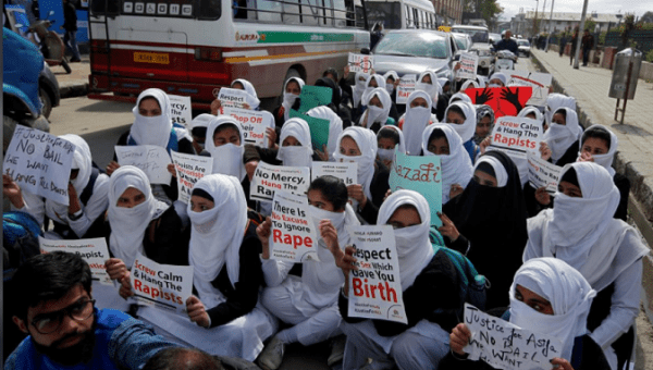 Schoolgirls holding placards sit in a road during a protest against the rape of several minor girls, in Srinagar April 17, 2018. 