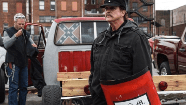 A National Socialist Movement member holds a shield during a white supremacist rally. 