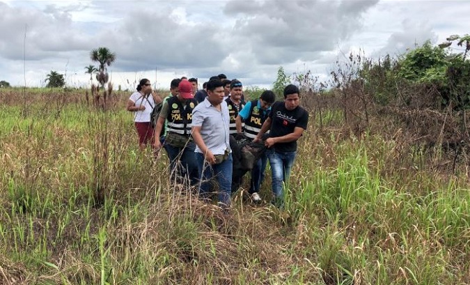 Police carry the body of Sebastian Woodroffe, who was beaten and strangled in Ucayali on Friday after being accused of killing a revered medicine woman,