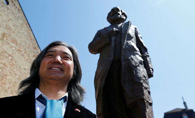 Chinese artist Wu Weishan poses next to his 4.4 meter-high bronze statue of Karl Marx in Trier, Germany.