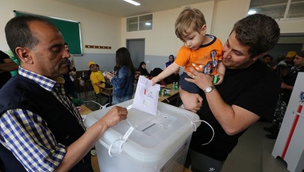 A child casts a ballot on behalf of his father during the parliamentary election in Tibnin, Lebanon, May 6, 2018.