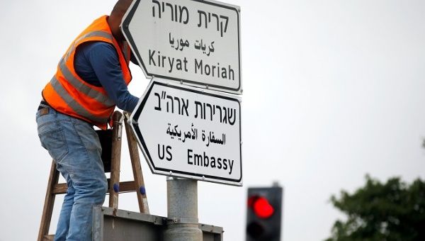 A worker hangs a road sign directing to the U.S. embassy, in the area of the U.S. consulate in Jerusalem, May 7, 2018. 