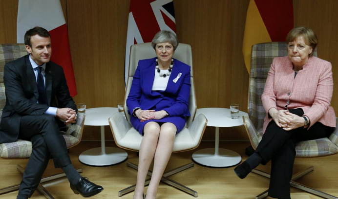 Britain's Prime Minister Theresa May is flanked by French President Emmanuel Macron and German Chancellor Angela Merkel before their trilateral meeting at the European Union leaders summit in Brussels, Belgium, March 22, 2018.