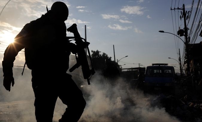Security forces attempt to extinguish a fire set by protestors in the Cidade de Deus favela.