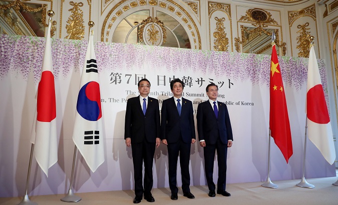 Chinese Premier Li Keqiang, Japanese Prime Minister Shinzo Abe and South Korean President Moon Jae-in pose for photographers prior to their summit in Tokyo, May 9, 2018.