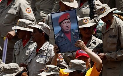 A supporter of Venezuela's President Nicolas Maduro holds a picture of the late Hugo Chavez at a rally in Caracas.
