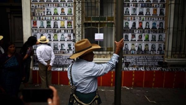 A man sees the pictures of about 40,000 people that went missing during the Guatemalan civil war. House of Memory, Guatemala City, May 10, 2018.