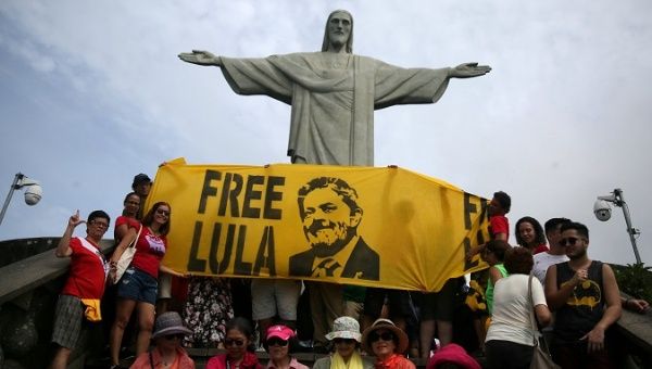 Supporters of former Brazilian President Luiz Inacio Lula da Silva display a banner in front of the statue of Christ the Redeemer in Rio de Janeiro, Brazil April 14, 2018. 